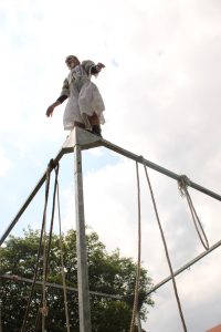 Foto einer Person auf einem Metallgerüst stehend